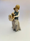 Lladro girl holding a basket of puppies