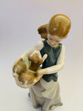 Lladro girl holding a basket of puppies