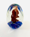 Egg Shaped Paperweight with Red Spiral Twist on a Blue Base