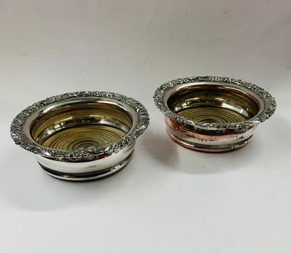 Pair of antique ornate silver plated over copper wine bottle coasters