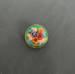 Round Brooch with Enamel Inlayed Flowers on a Green Background